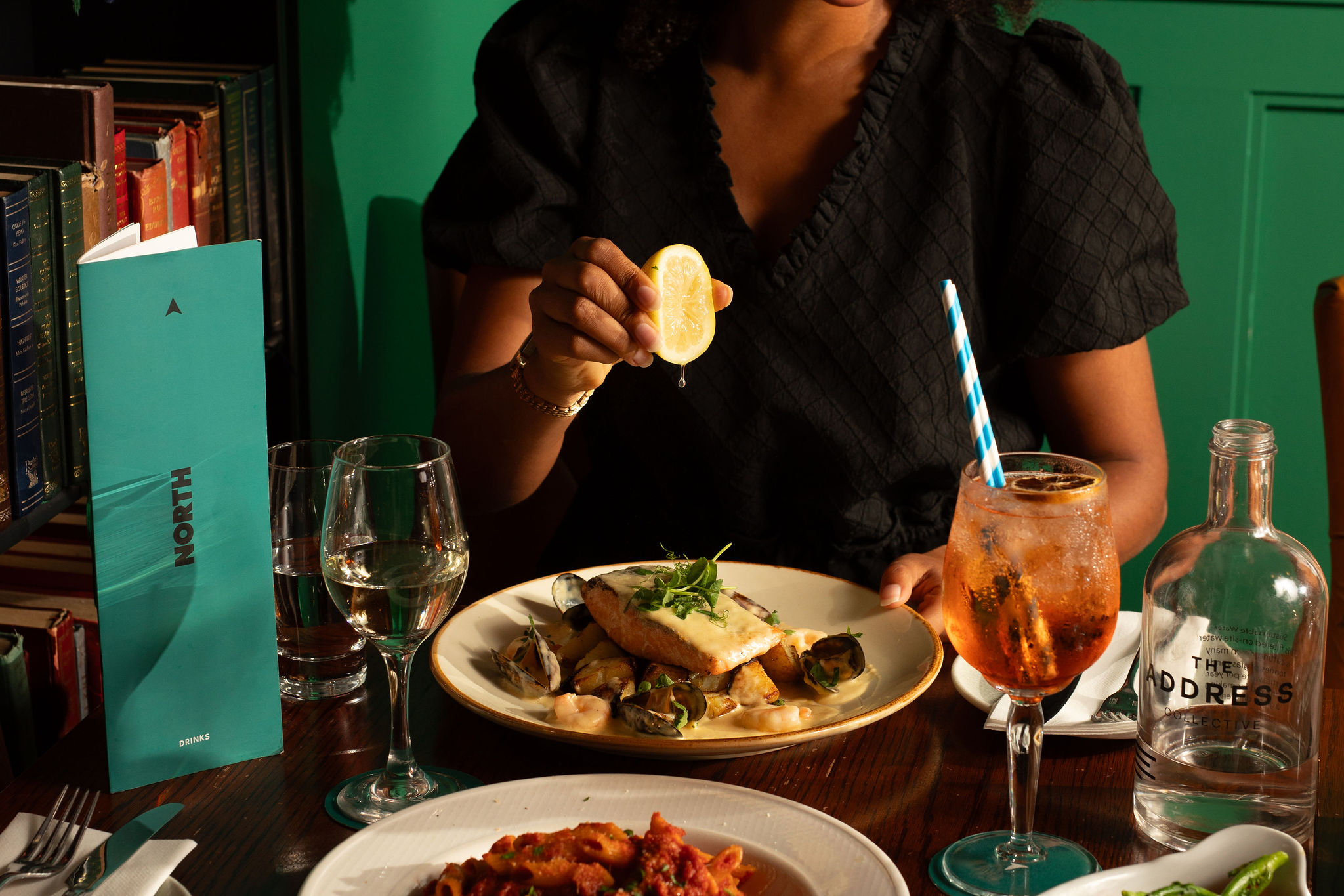 A diner squeezing lemon over a fish dish at NORTH restaurant in The Address Cork